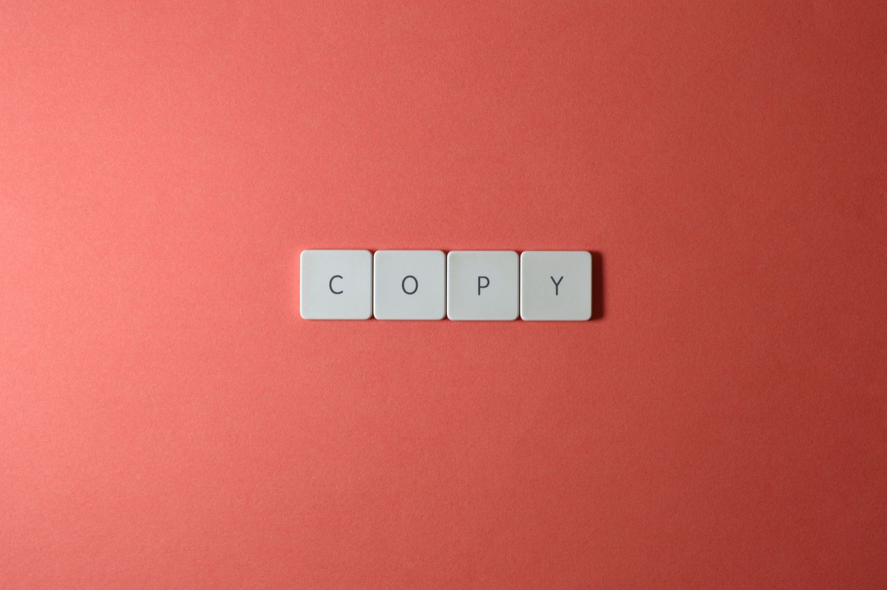 Simple arrangement of keyboard keys spelling COPY on a coral surface, perfect for creative concepts.