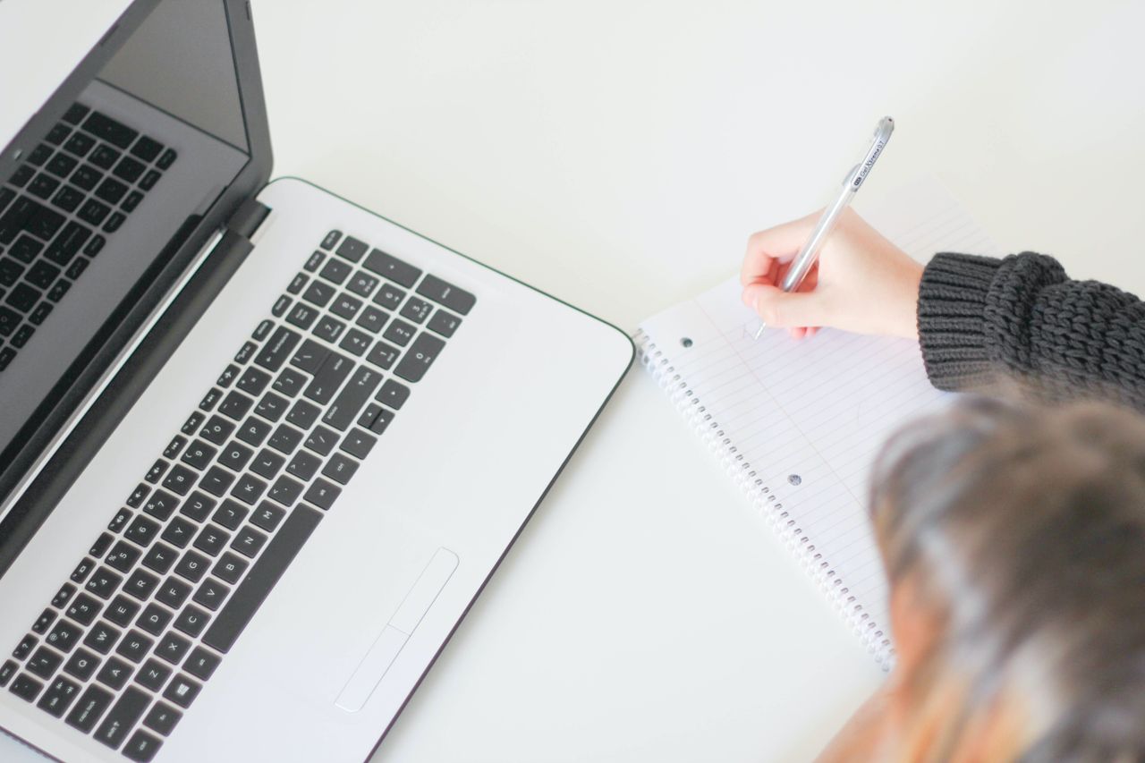 Casual home office setup with laptop and notebook, ideal for freelancers.